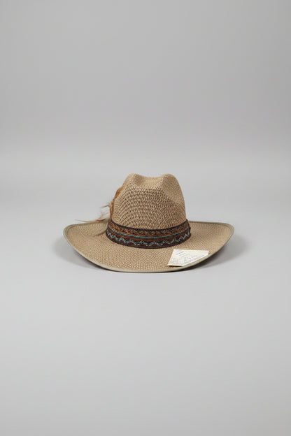 Brown straw hat with a band on a textured surface