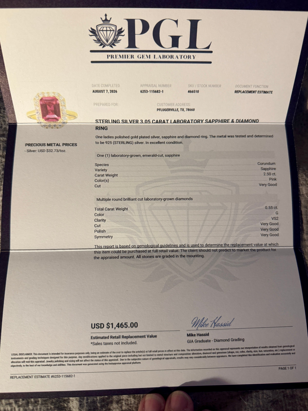 A PGL (Premier Gem Laboratory) replacement estimate card for a sterling silver cabochon lab-sourced diamond ring, featuring a pink gemstone illustration and product details, with a finger visible at the bottom.