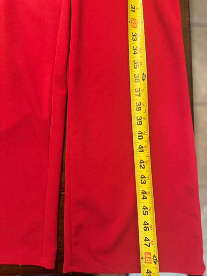 Close-up of red fabric with a yellow measuring tape laid vertically down the center to show dimensions.