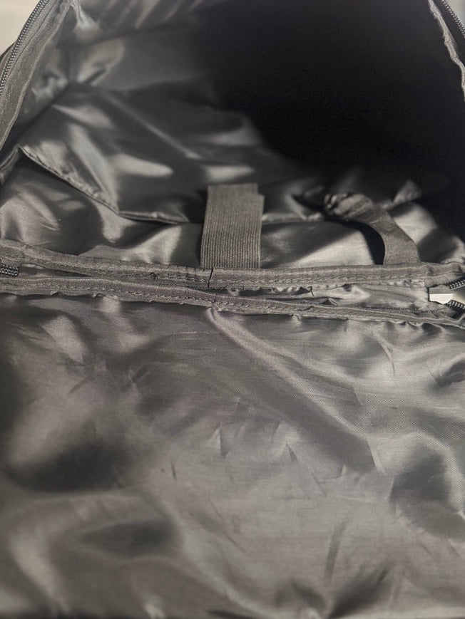 Close-up of an open black nylon or polyester bag showing the interior lining, zipper compartments, and fabric texture.