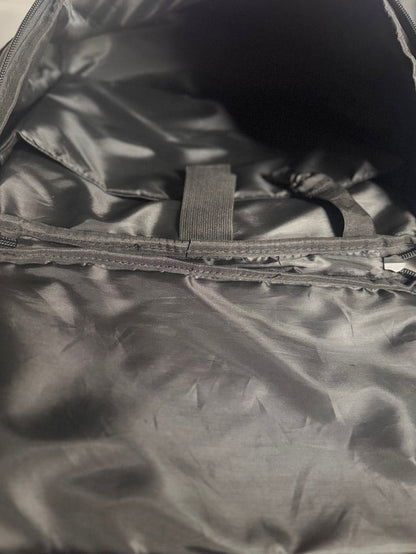 Close-up of an open black nylon or polyester bag showing the interior lining, zipper compartments, and fabric texture.