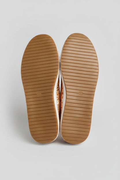 Close-up of beige shoe soles with a blurred indoor background
