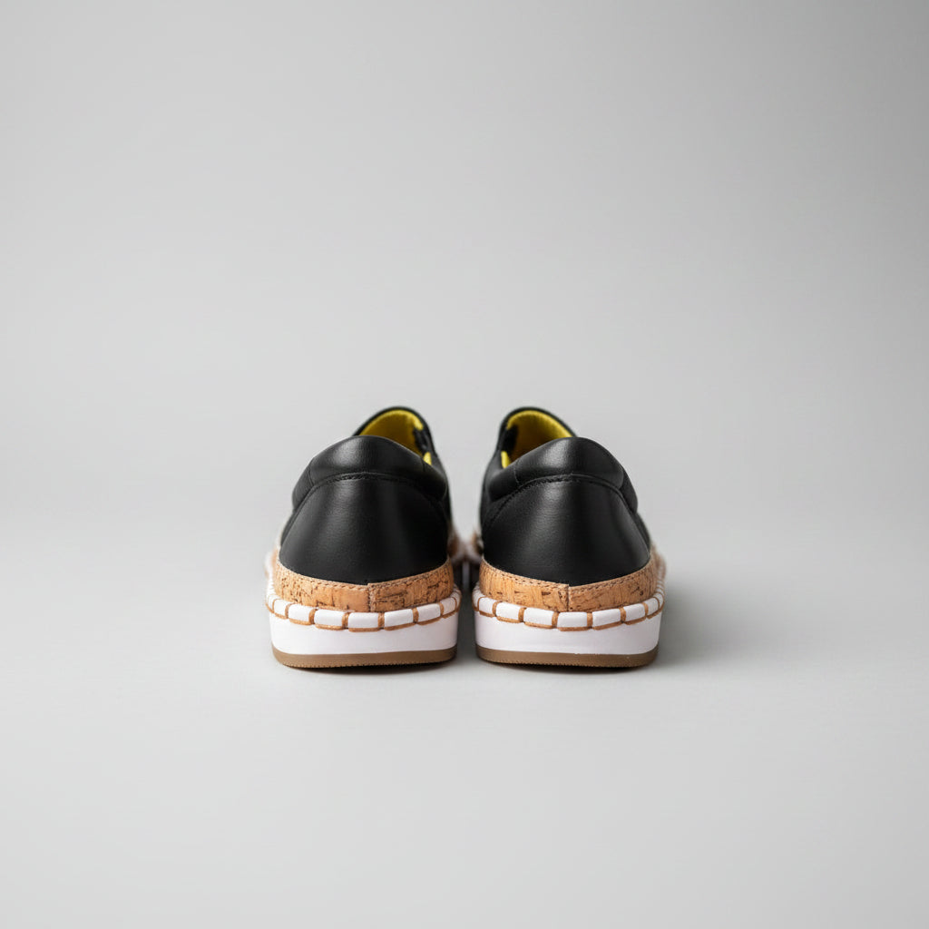 Pair of black and brown shoes on a light wooden floor.