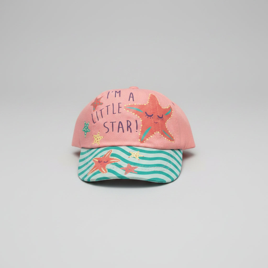 A children's baseball cap resting on a textured beige carpet. The cap features a coral pink crown with the text 'I'M A LITTLE STAR!' and embroidered orange starfish, paired with a teal and white wavy striped brim decorated with starfish and sea-creature prints.