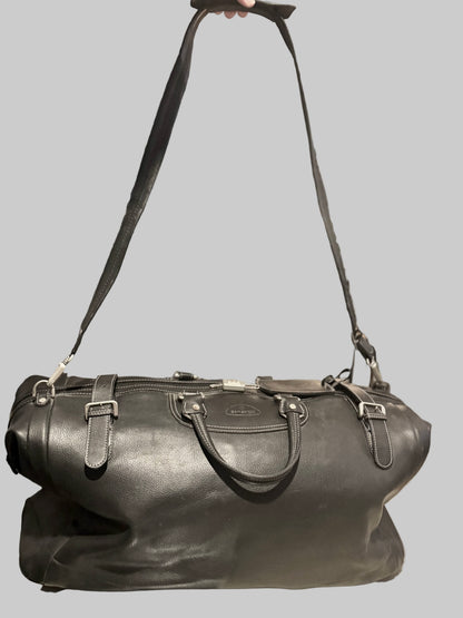 Black leather duffel bag with a strap on a gray background