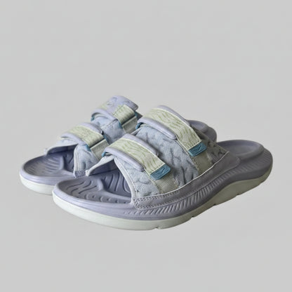 Pair of gray sandals with velcro straps on a light gray background