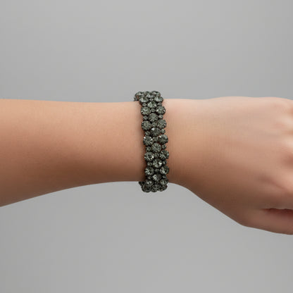 Close-up of a wrist wearing a bracelet on a neutral background