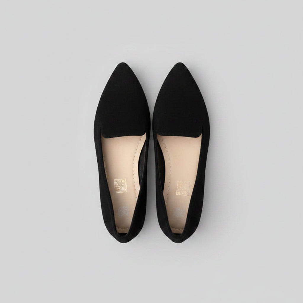 Black pointed-toe shoes on a flat surface