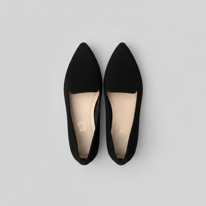 Black pointed-toe shoes on a flat surface