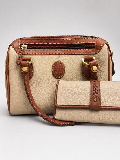 A beige pebbled leather handbag with brown leather trim and a matching zip-around wallet, photographed on a light gray studio background.