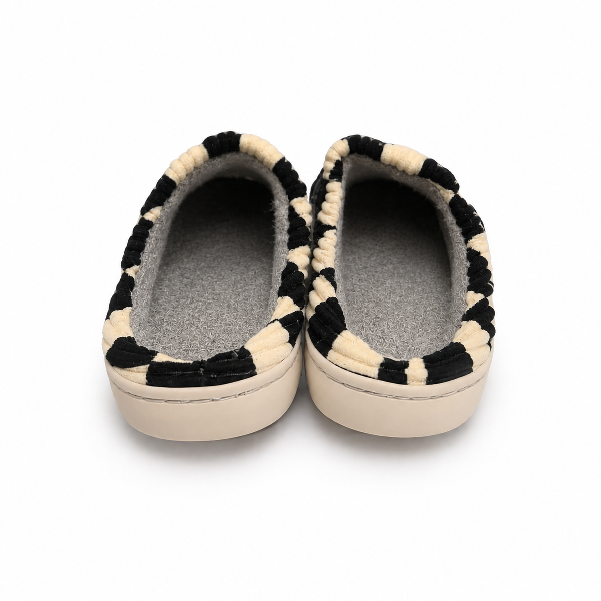 A pair of slip-on slippers with a black and cream striped textured fabric upper and a soft gray fleece lining, shown from a top-down view on a white background.