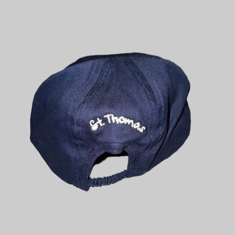 A dark navy blue baseball cap with 'St. Thomas' embroidered in white script on the front, shown against a solid gray background.