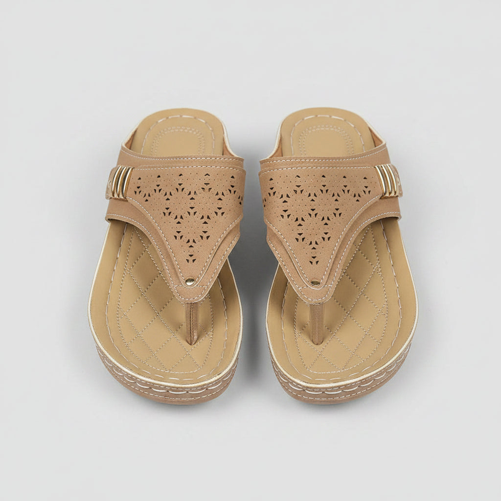 Pair of beige sandals on a wooden floor with a blurred background