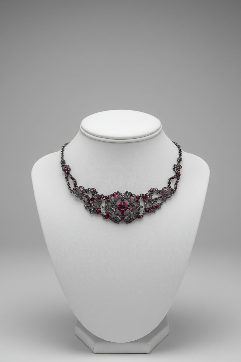 Decorative necklace with red stones on a white surface