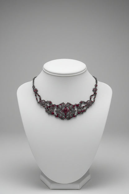 Decorative necklace with red stones on a white surface