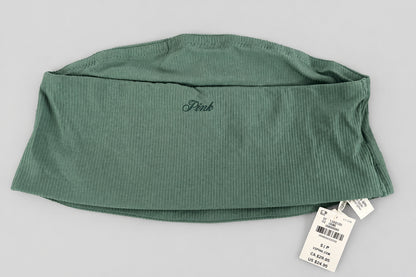 A folded sage green ribbed knit garment, likely leggings or a pant leg, with a small dark script logo on the side and a white retail tag attached, laid flat on a textured gray fabric background.
