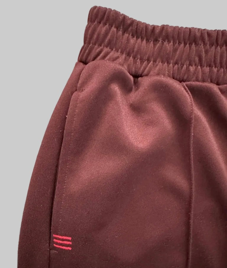 Close-up of maroon sweatpants with a gray background