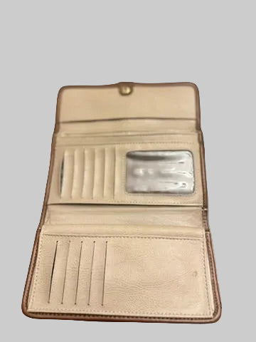 An open beige leather wallet with multiple card slots, a clear ID window, and a snap button closure, resting on a dark wood surface.