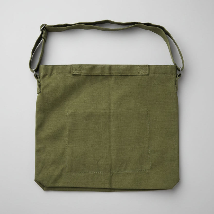 Green bag with a strap on a white surface