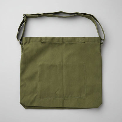 Green bag with a strap on a white surface