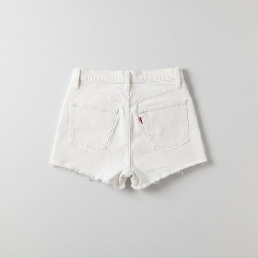 White shorts with a brand logo on a gray textured surface