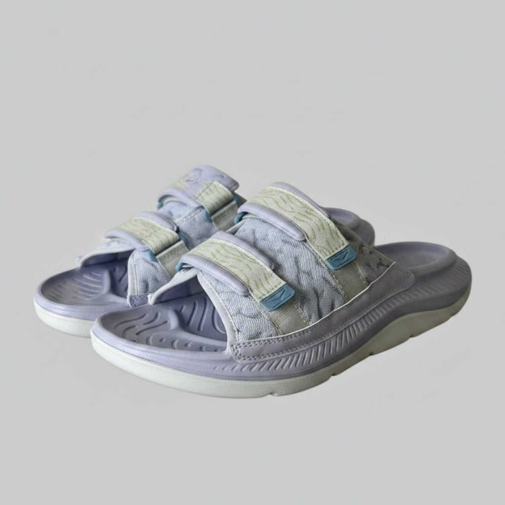 Gray and white sandals with a textured sole on a light gray background
