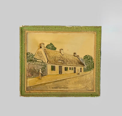 Decorative tile with a house design on a plain background