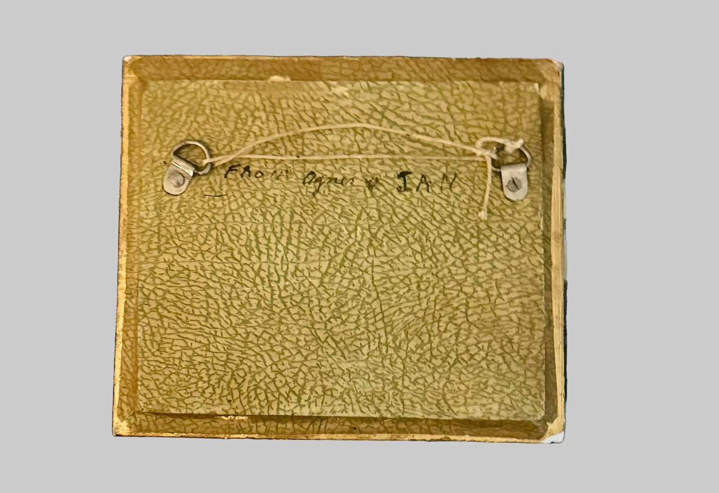 Brown leather wallet with stitching details on a plaid fabric background