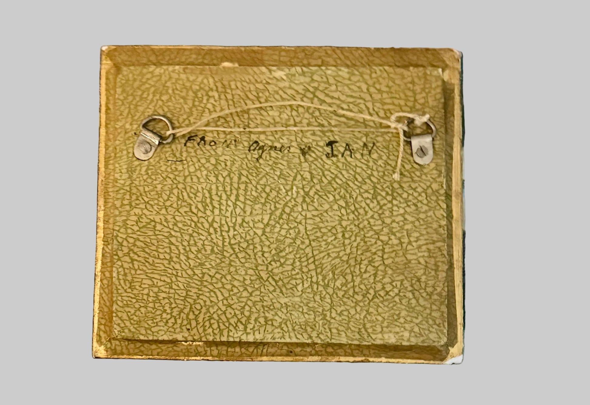 Brown leather wallet with stitching details on a plaid fabric background