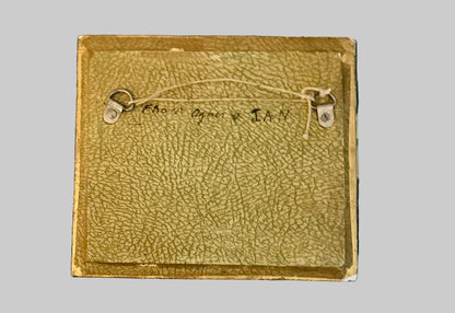 Brown leather wallet with stitching details on a plaid fabric background