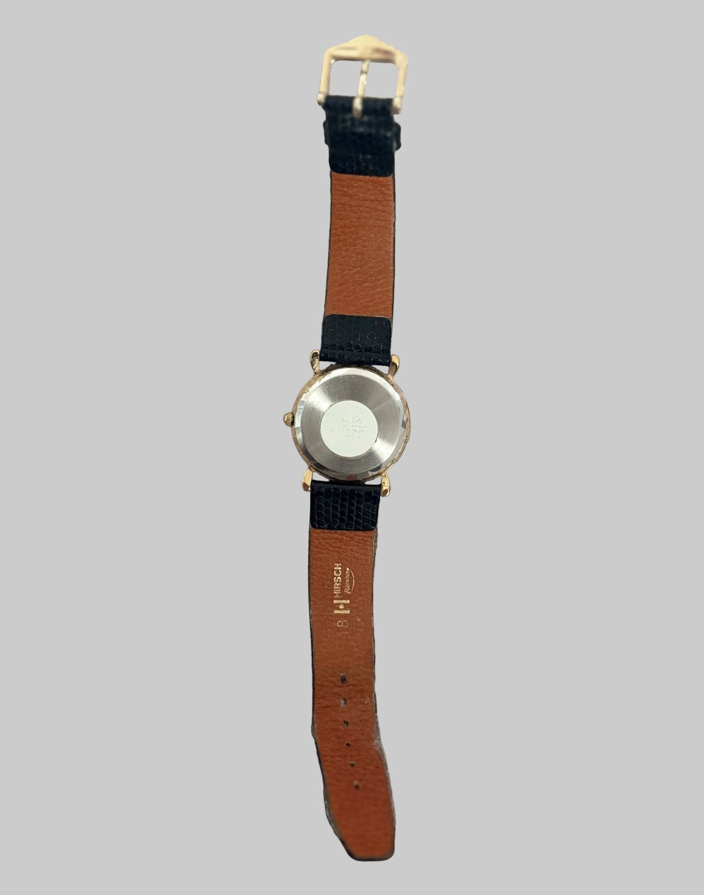 Watch with a brown strap on a gray background