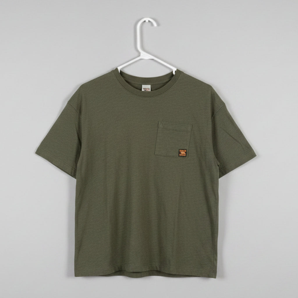 An olive green short-sleeve pocket t-shirt hanging on a white plastic hanger against a textured off-white wall.