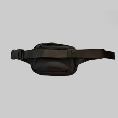 A black nylon fanny pack with a wide adjustable strap and plastic buckle, shown against a solid gray background.