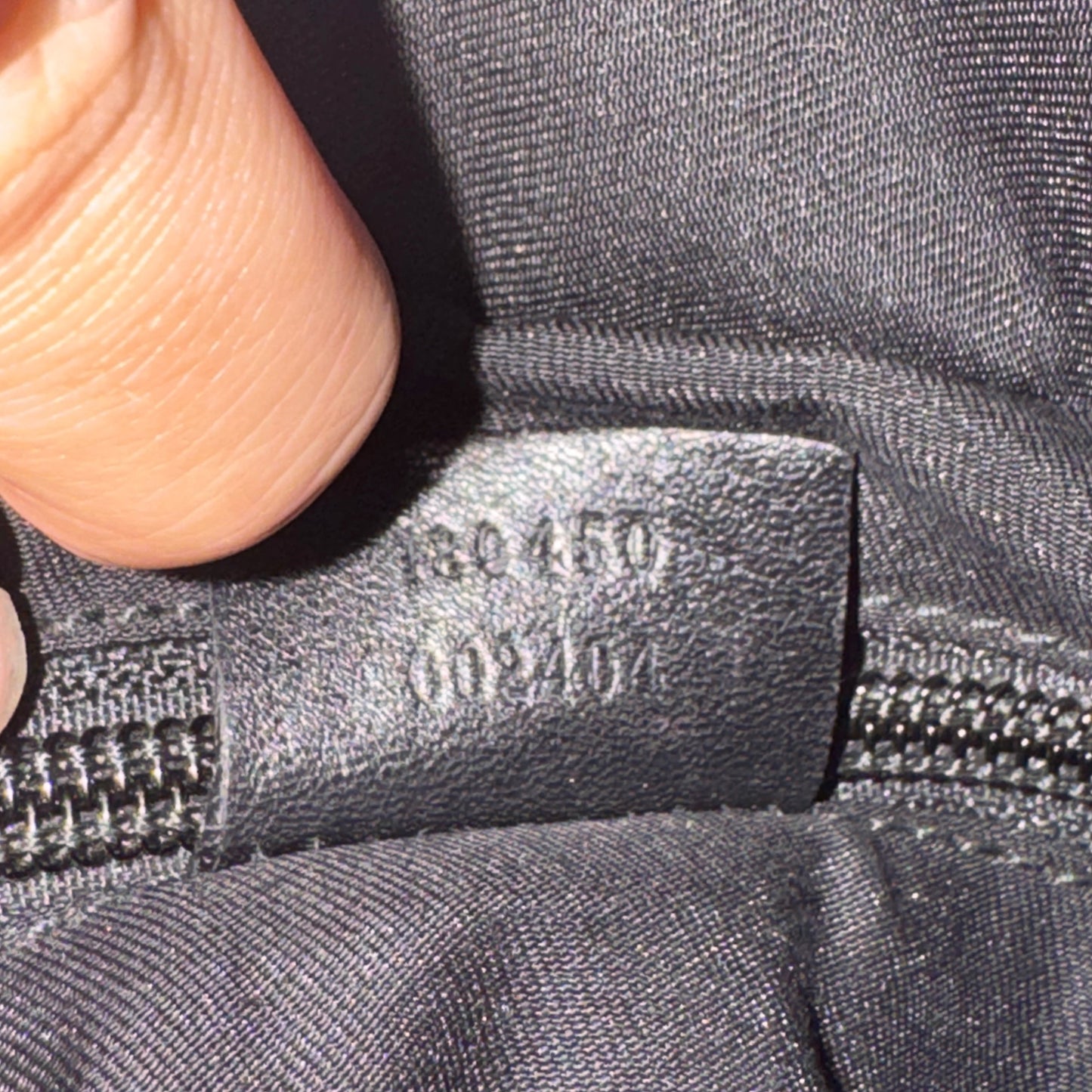 Close-up of a zipper with a brand label on a gray fabric background