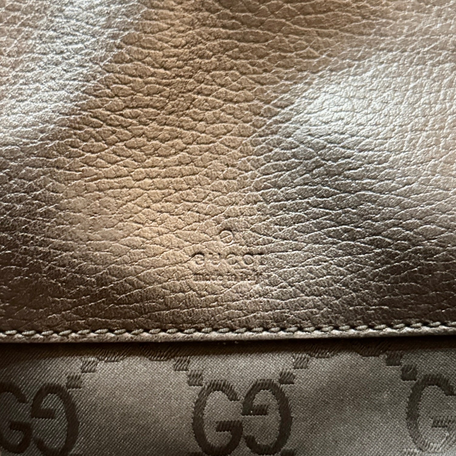 Close-up of Gucci leather product with logo pattern