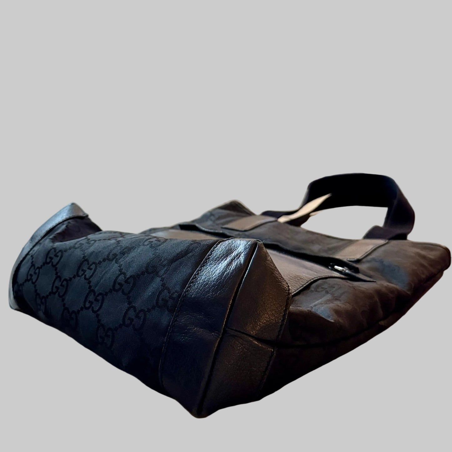 Black quilted handbag on a wooden table with a kitchen in the background
