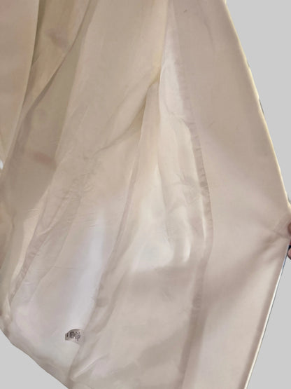 Close-up of a white garment with a brand logo on a blurred background