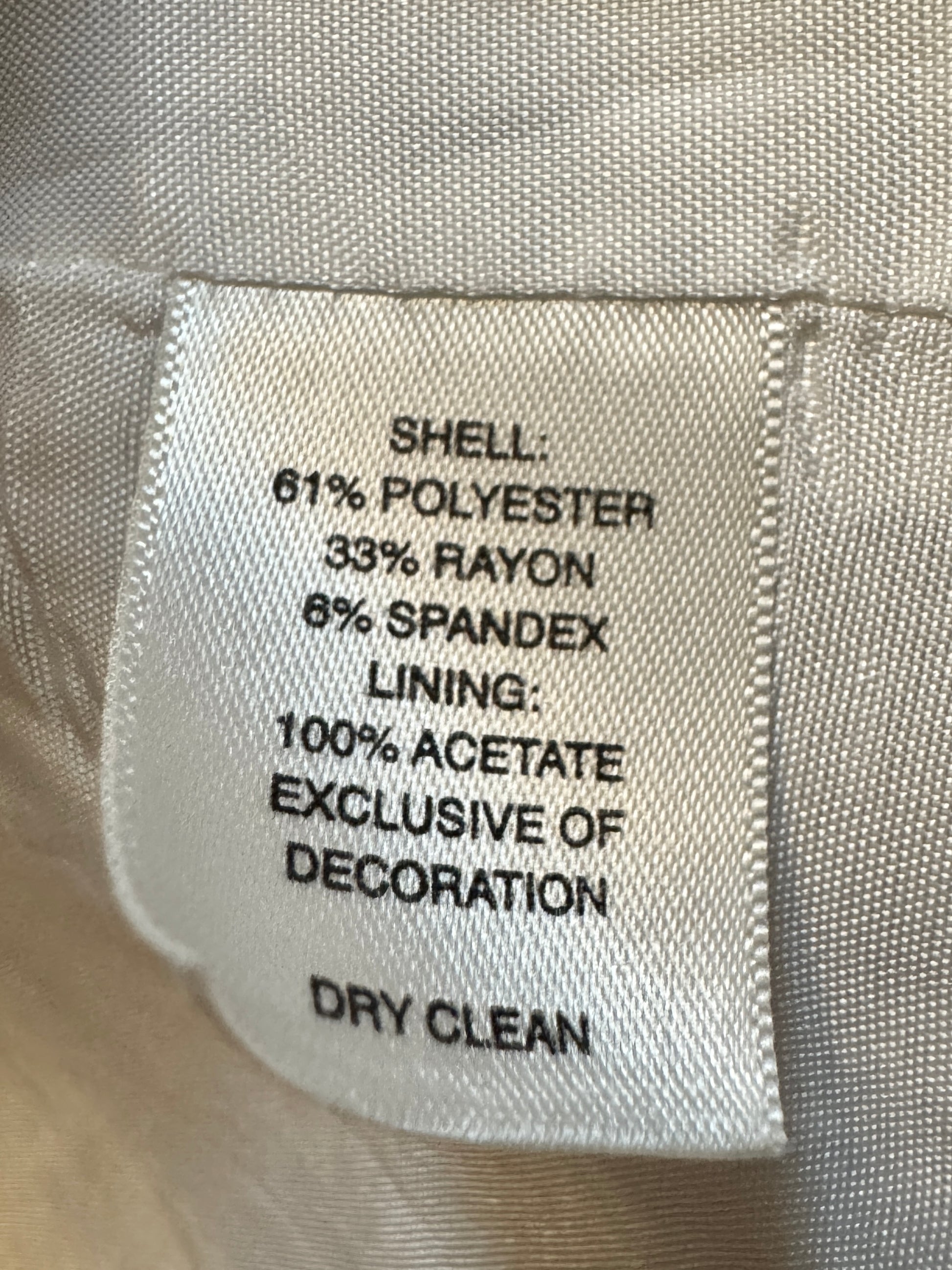 Fabric label with material composition details on a beige fabric background