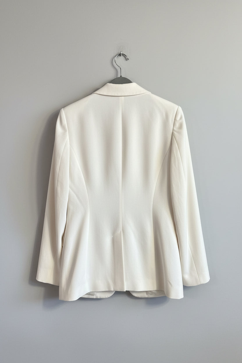 White blazer hanging on a door