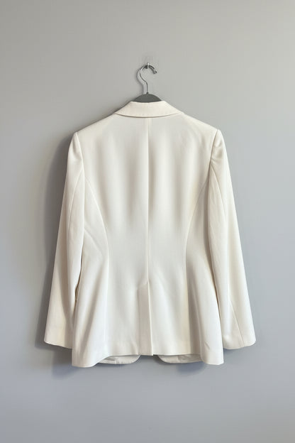 White blazer hanging on a door