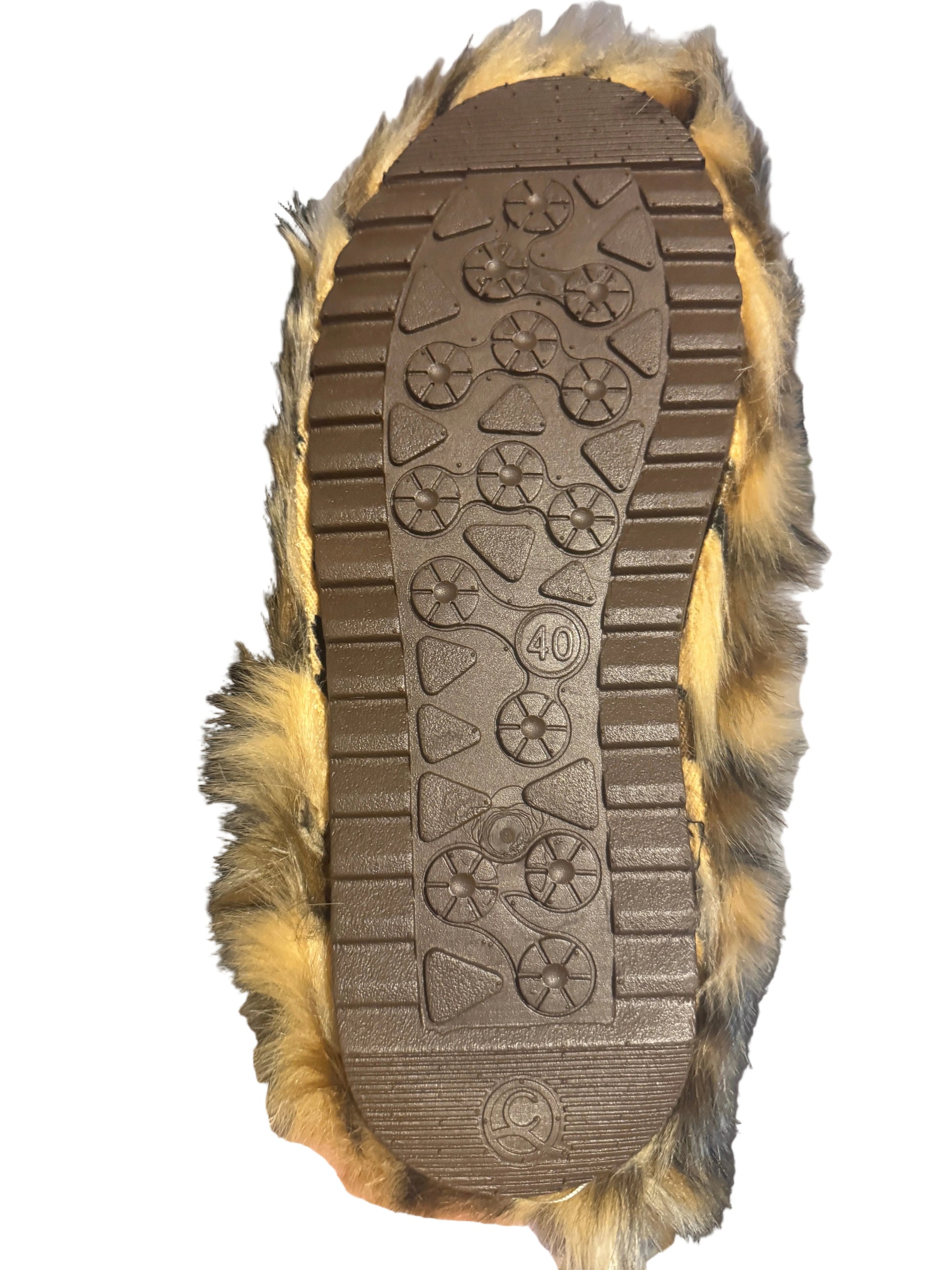 A close-up of a brown rubber shoe sole with tread patterns and a size 40 marking, surrounded by tan and brown faux fur, held up in a home setting.