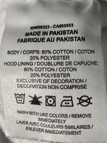 A close-up of a sewn-on fabric care label showing product details including 'Made in Pakistan' and material composition in cotton and polyester.