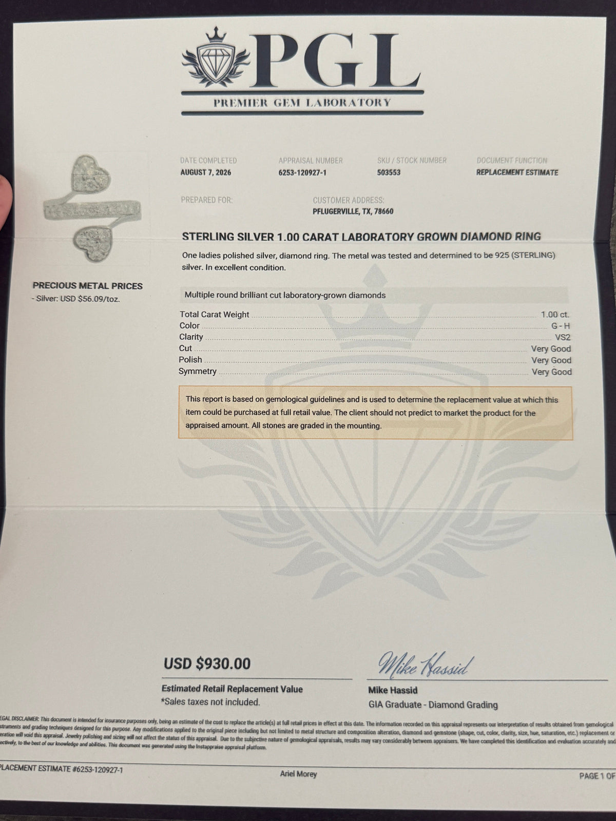 A hand holds a PGL (Premier Gem Laboratory) diamond replacement certificate for a Steven & Silvery 1.0 carat laboratory grown diamond ring, displayed against a gray textured background.