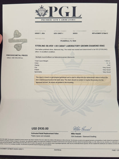 A hand holds a PGL (Premier Gem Laboratory) diamond replacement certificate for a Steven & Silvery 1.0 carat laboratory grown diamond ring, displayed against a gray textured background.