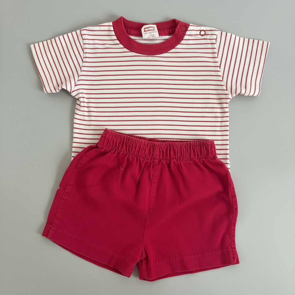 A baby clothing set consisting of a short-sleeve top with red and white horizontal stripes and a solid red collar, paired with solid red shorts, laid flat on a gray textured blanket.