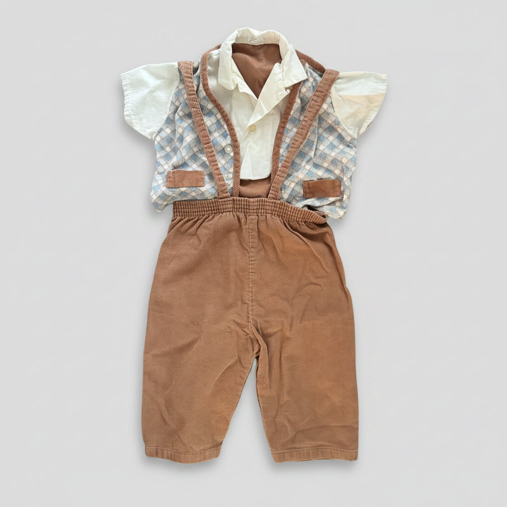 A baby boy's short-sleeve vest and shorts outfit laid flat on a textured gray fabric background. The outfit features brown corduroy suspenders and shorts, a white button-up shirt, and a light blue and white gingham patterned vest.