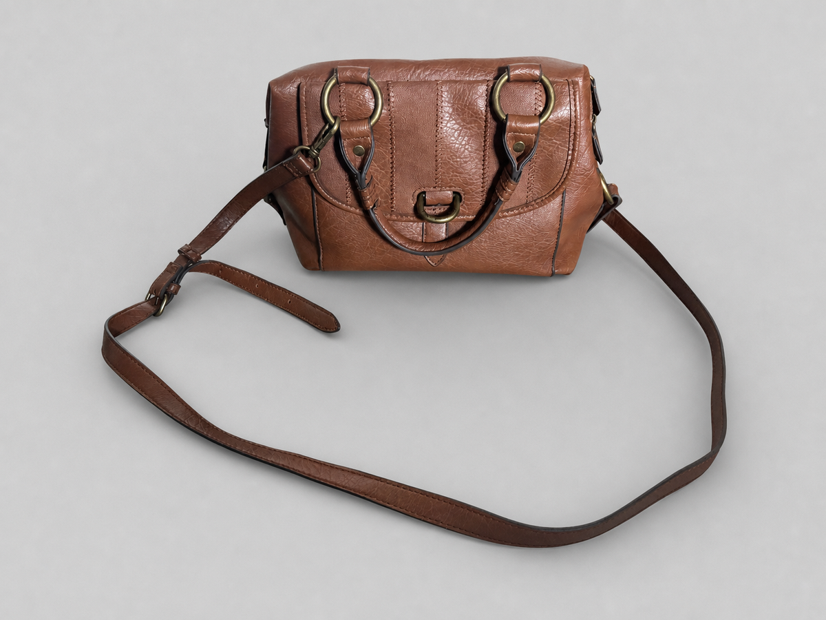 A brown leather handbag with a long shoulder strap, gold-tone hardware, and a structured rectangular silhouette, photographed on a plain light gray background.