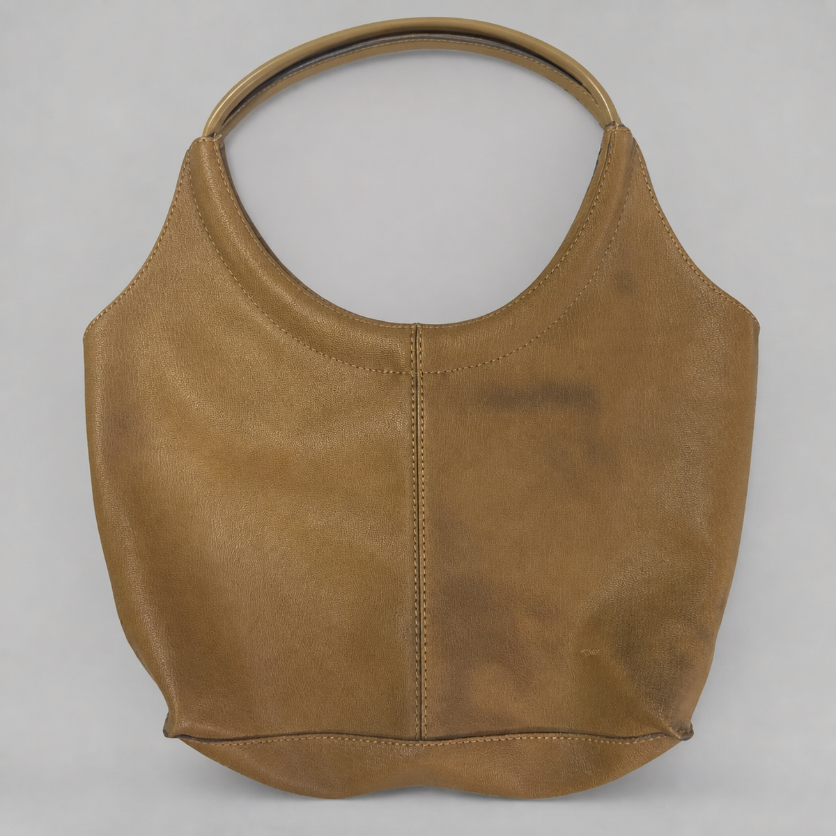 A tan leather shoulder bag with a single circular top handle, photographed against a neutral light gray background.
