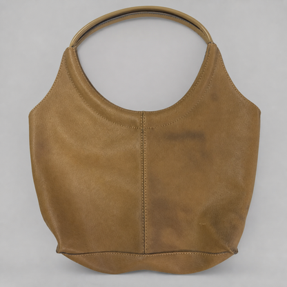 A tan leather shoulder bag with a single circular top handle, photographed against a neutral light gray background.