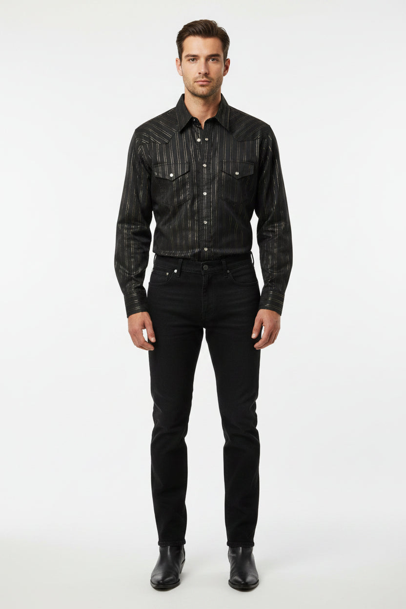 A black long-sleeve button-up shirt with thin vertical metallic gold stripes, laid flat on a beige carpet next to a blue rug.